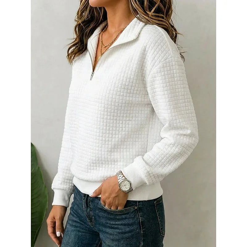 Side angle of a white textured quarter-zip jumper showing the ribbed cuffs and hem detail