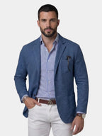 Front view of man wearing a blue textured linen blazer open over a striped shirt and white trousers