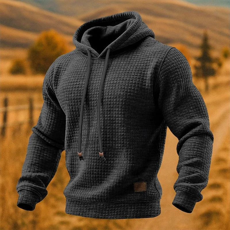Dark grey waffle-knit pullover hoodie shown from a slight side angle highlighting the hood shape