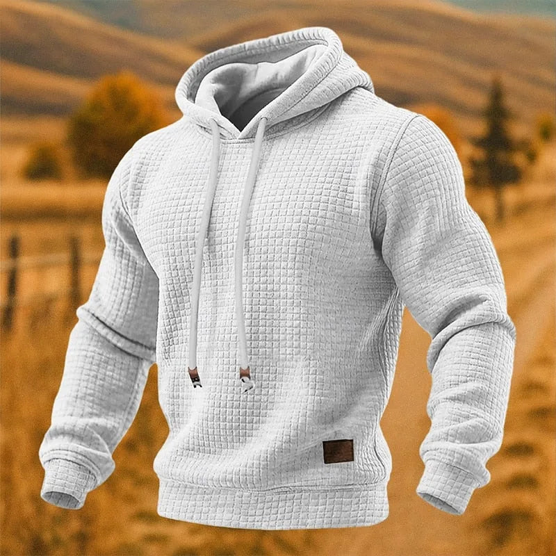 White textured pullover hoodie with drawstring hood and small brown logo patch at the hem