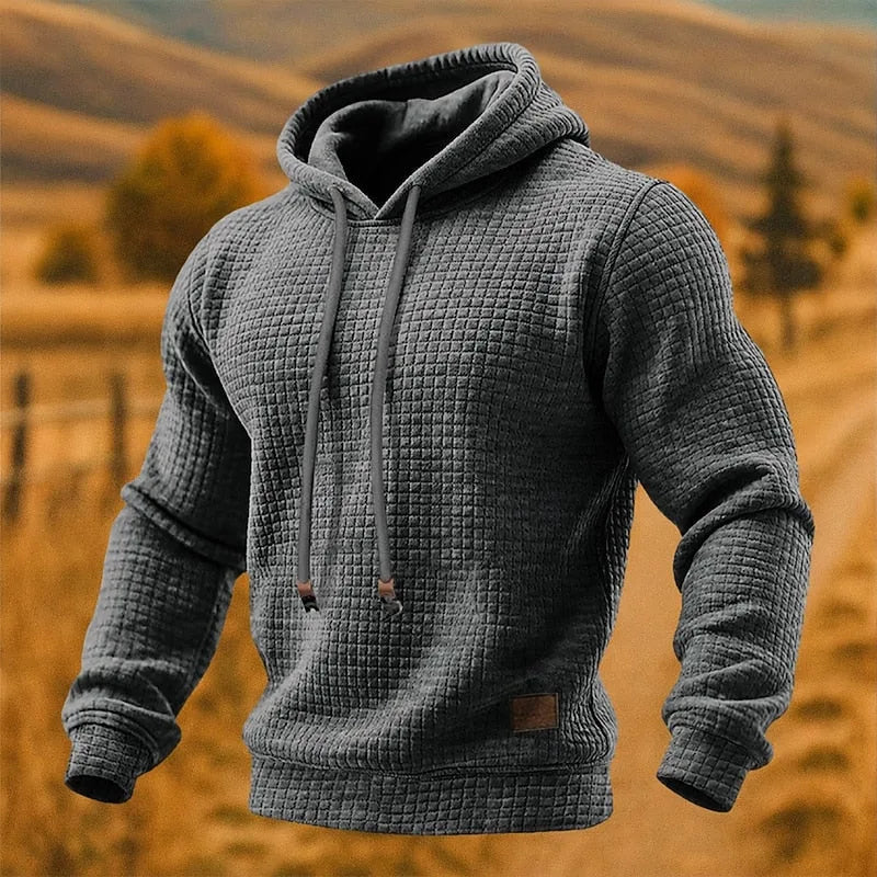 Charcoal grey waffle-textured hoodie, close front view showing ribbed cuffs and drawcord toggles