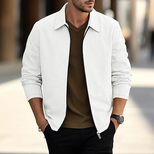 Front view of a white textured zip-up overshirt worn open over a brown top, styled with black trousers