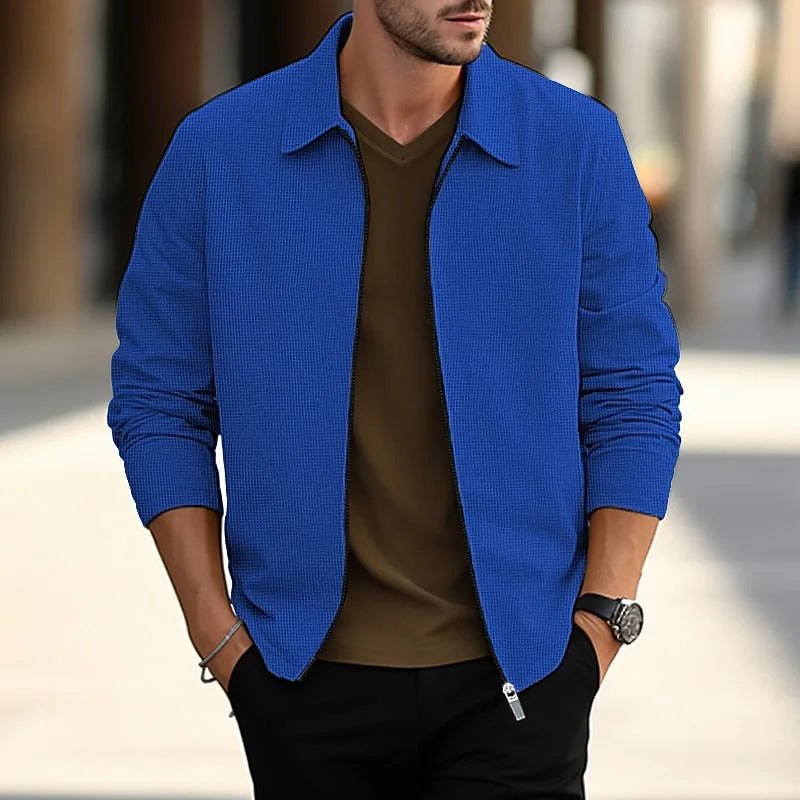 Blue textured overshirt with point collar and front zip, worn open over a brown polo shirt