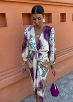 Front view of the wrap dress showing the tied waist sash, balloon sleeves with elastic cuffs and plunging neckline