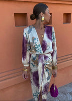 Side profile of the wrap dress highlighting the draped tie waist, gold bangles and teardrop earrings