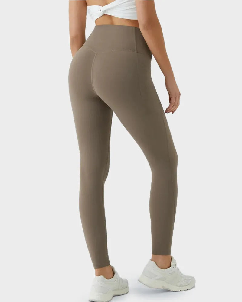 Back view of taupe leggings highlighting the seamed, butt-lifting panel design and smooth stretch fabric