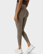 Side angle of taupe leggings showing the curved seam detail over the hip and pocket placement along the thigh