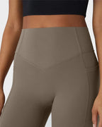 Close-up of the high-waisted waistband with V-shaped seam detailing and side pocket opening on taupe leggings