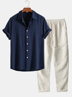 Navy blue linen-look shirt paired with cream drawstring trousers, close view of collar and cuffs