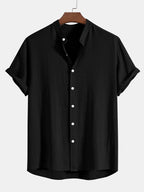 Black stand-collar shirt with button placket, front view laid flat on hanger