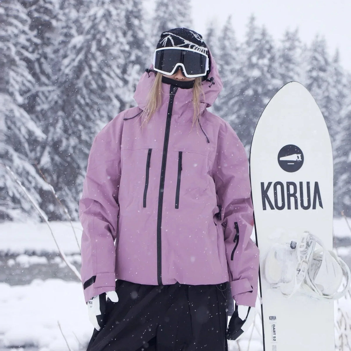 Front view of a mauve pink ski jacket with adjustable hood, zip pockets and drawstring hem in falling snow