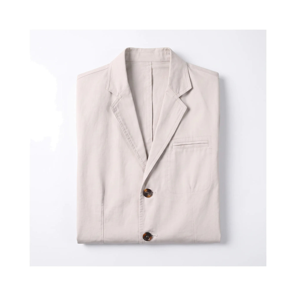 Beige cotton blazer neatly folded, showing the chest pocket and front button placket