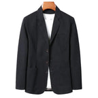 Black cotton blazer on a wooden hanger, front view showing patch pockets and button front