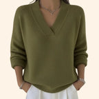 Woman modelling an olive green V-neck knit jumper with a wrap-style neckline and ribbed trims