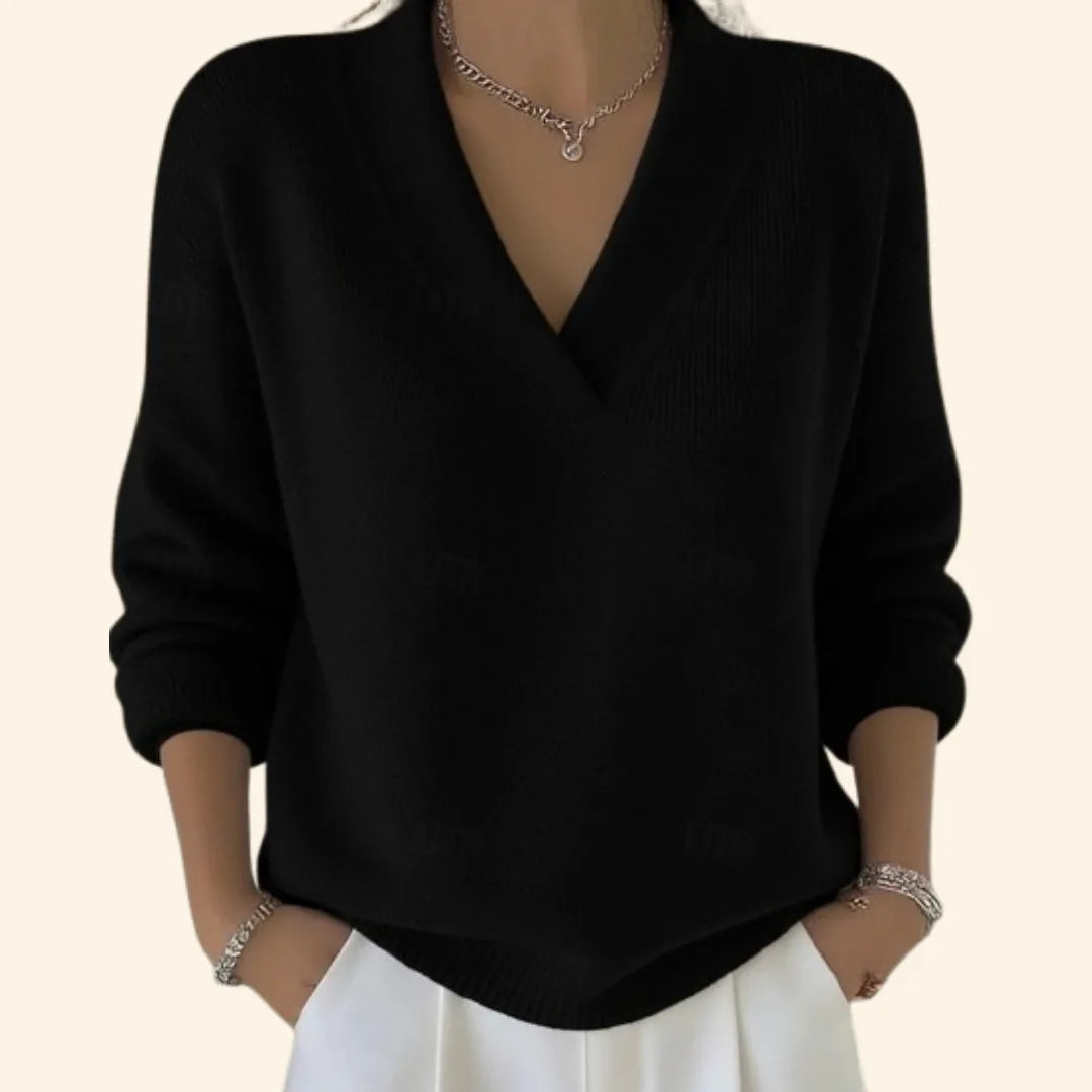 Detail shot of a black V-neck jumper showing its ribbed collar, dropped shoulder seams and relaxed silhouette