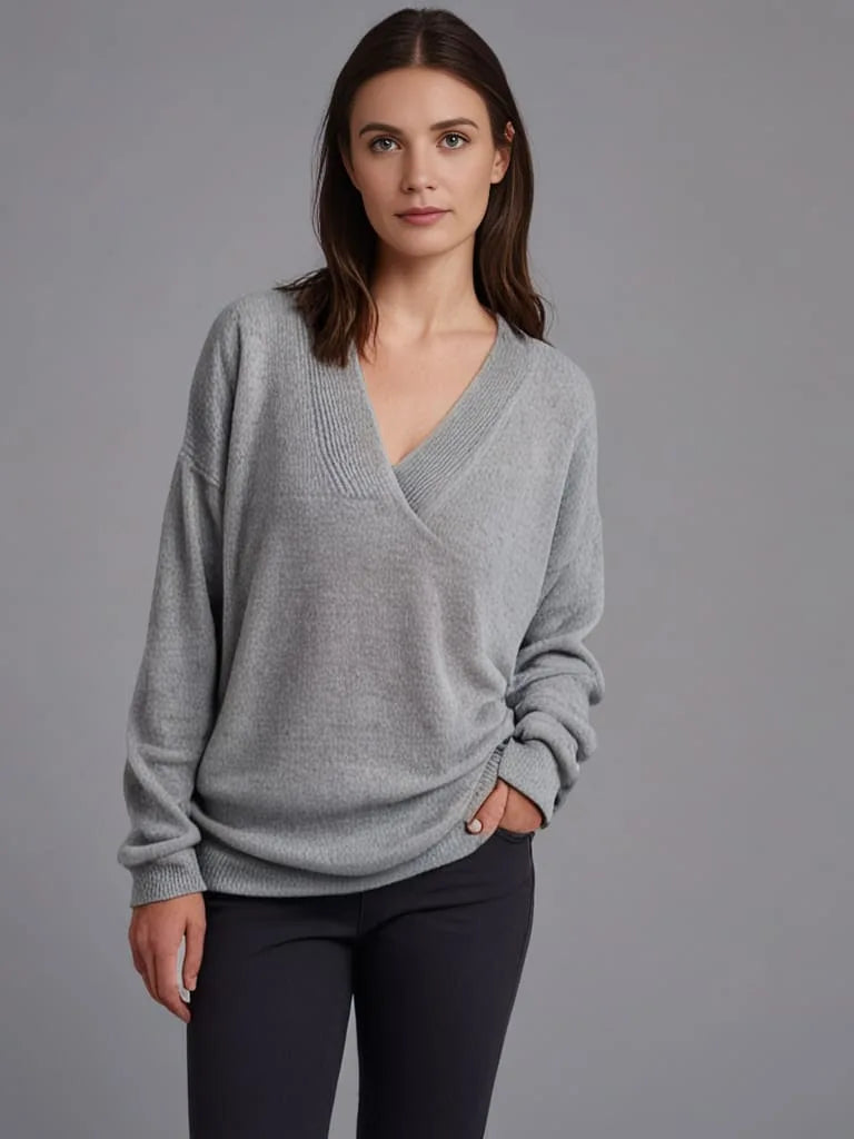 Front view of a grey wrap-style V-neck jumper with ribbed trim, worn with black trousers