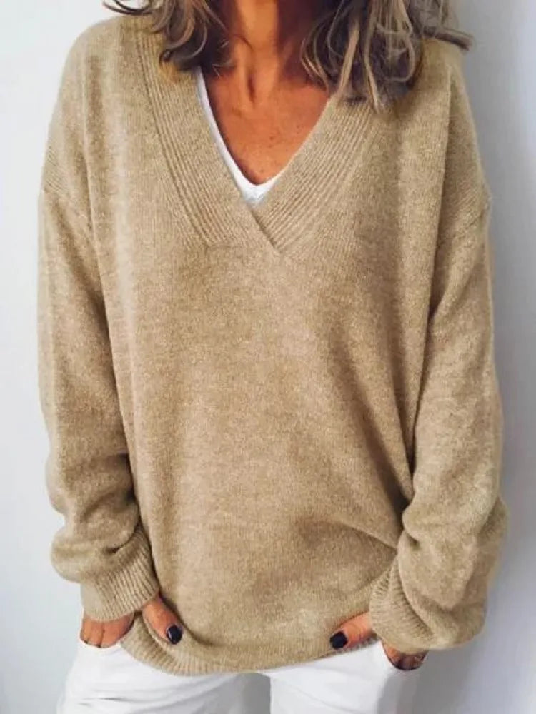 Close-up of a camel beige oversized V-neck jumper with ribbed V-neckline and dropped shoulders