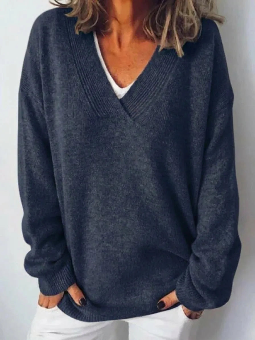 Close-up front view showing the ribbed V-neck trim and soft knit texture of the jumper