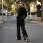 Back view of the black velour hoodie and trousers showing the cream side stripe running down the leg