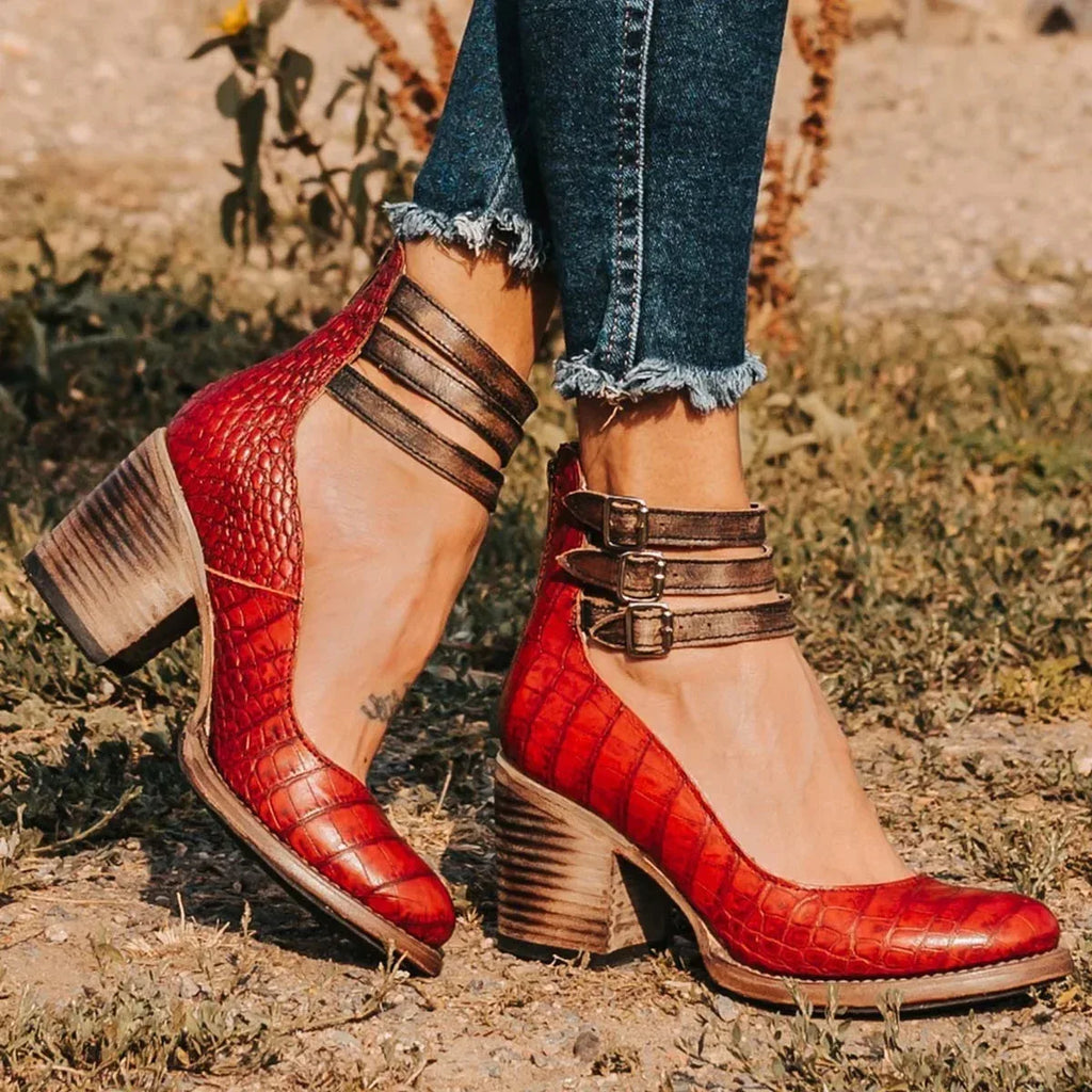 Red croc-embossed leather ankle strap heels with contrasting brown buckle straps and block heel