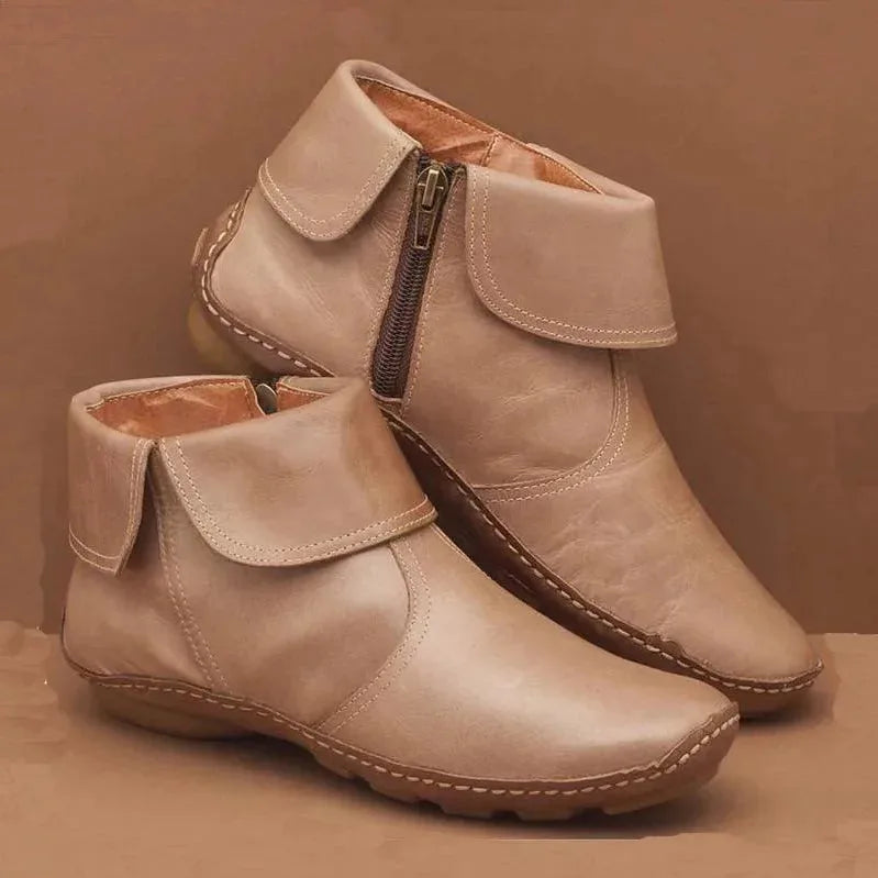 Beige leather ankle boots with foldover cuff and antique zip, showing tan lining and stacked sole