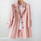 Pink trench-style coat with notch collar and button front, worn open over a white top