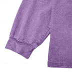 Close-up of the ribbed cuff and raglan sleeve seam on a purple washed henley shirt