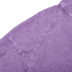Detail shot of the raglan shoulder seam and stitching on a purple washed henley shirt