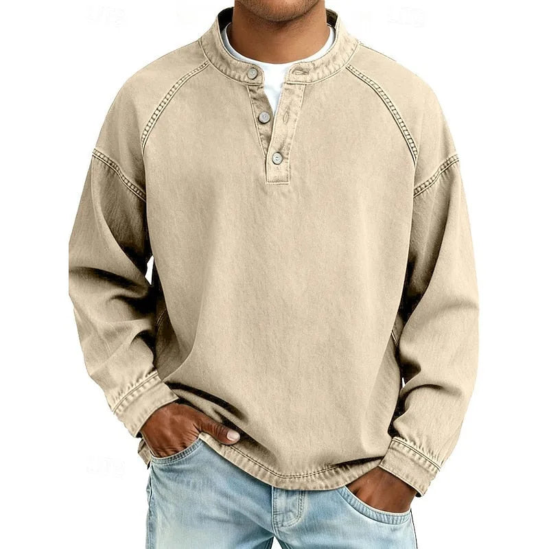 Front view of a man wearing a khaki washed henley shirt paired with light blue jeans