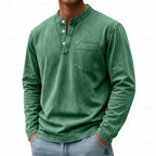 Man modelling a green washed henley shirt with visible chest pocket and stitched seams
