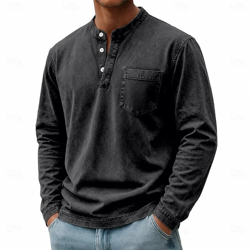 Man wearing a black washed henley shirt showing the open collar and three-button placket