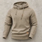 Khaki beige waffle-knit hoodie laid flat, highlighting cowl funnel neck and chunky basket-weave texture