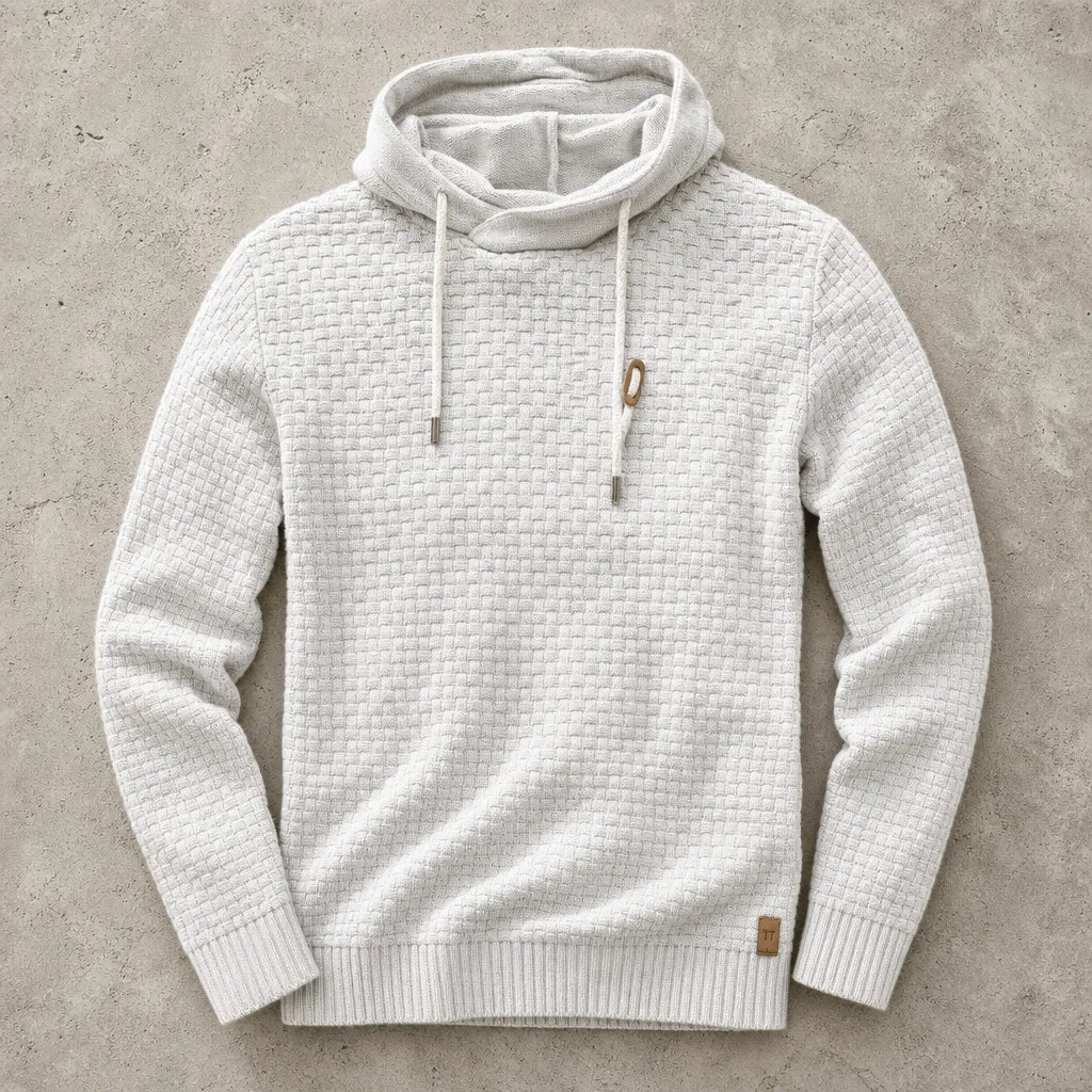 White marl waffle-knit hoodie laid flat, showing cowl collar and chunky knit texture up close