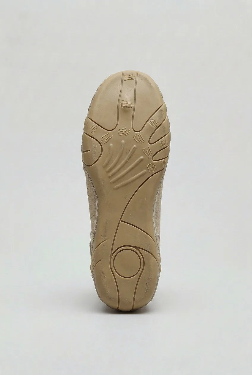 Underside view of the ridged rubber outsole showing textured grip pattern and curved heel design