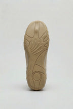 Underside view of the ridged rubber outsole showing textured grip pattern and curved heel design