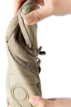 Close-up of hand pulling back the padded ankle collar to show the soft suede lining and side zip