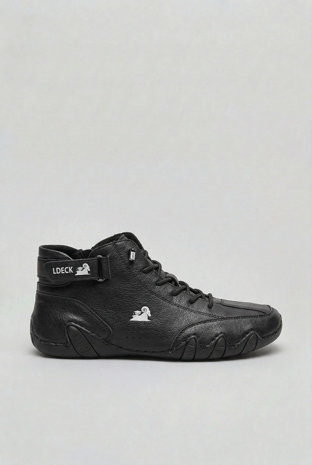 Side profile of the high-top boot in smooth black leather with a silver ram logo on the ankle strap