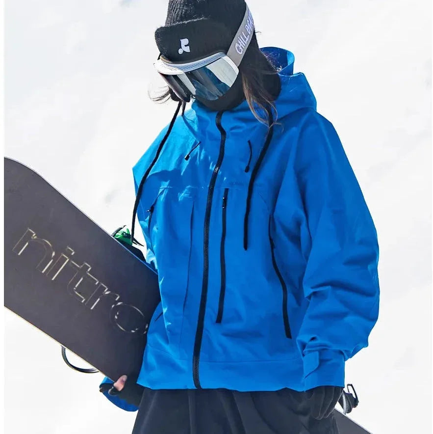 Close-up front angle of the blue ski jacket highlighting the storm hood and multiple zip pocket details