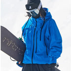 Close-up front angle of the blue ski jacket highlighting the storm hood and multiple zip pocket details