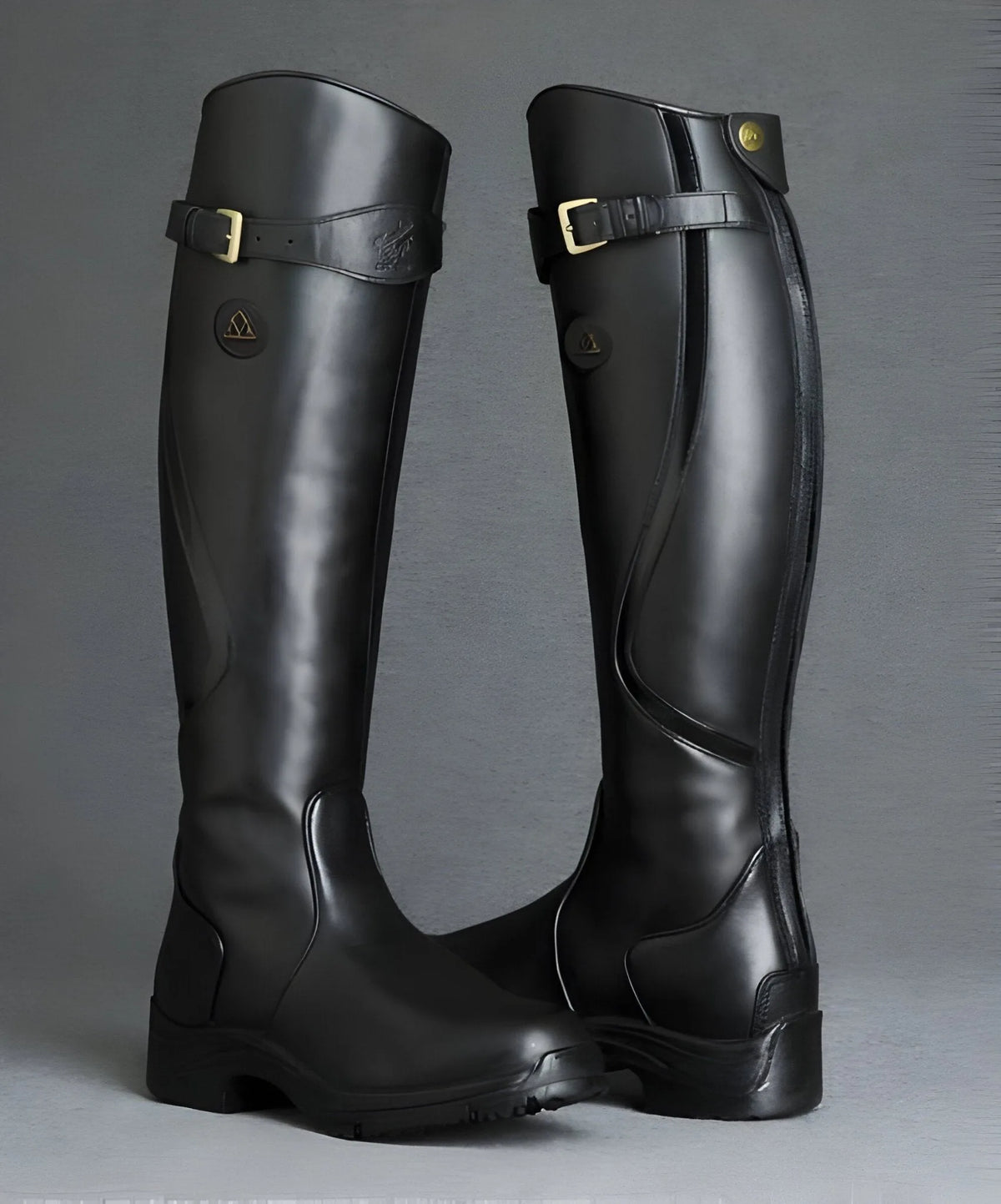 Pair of glossy black leather knee-high boots with buckle straps and branded heel patch, studio shot