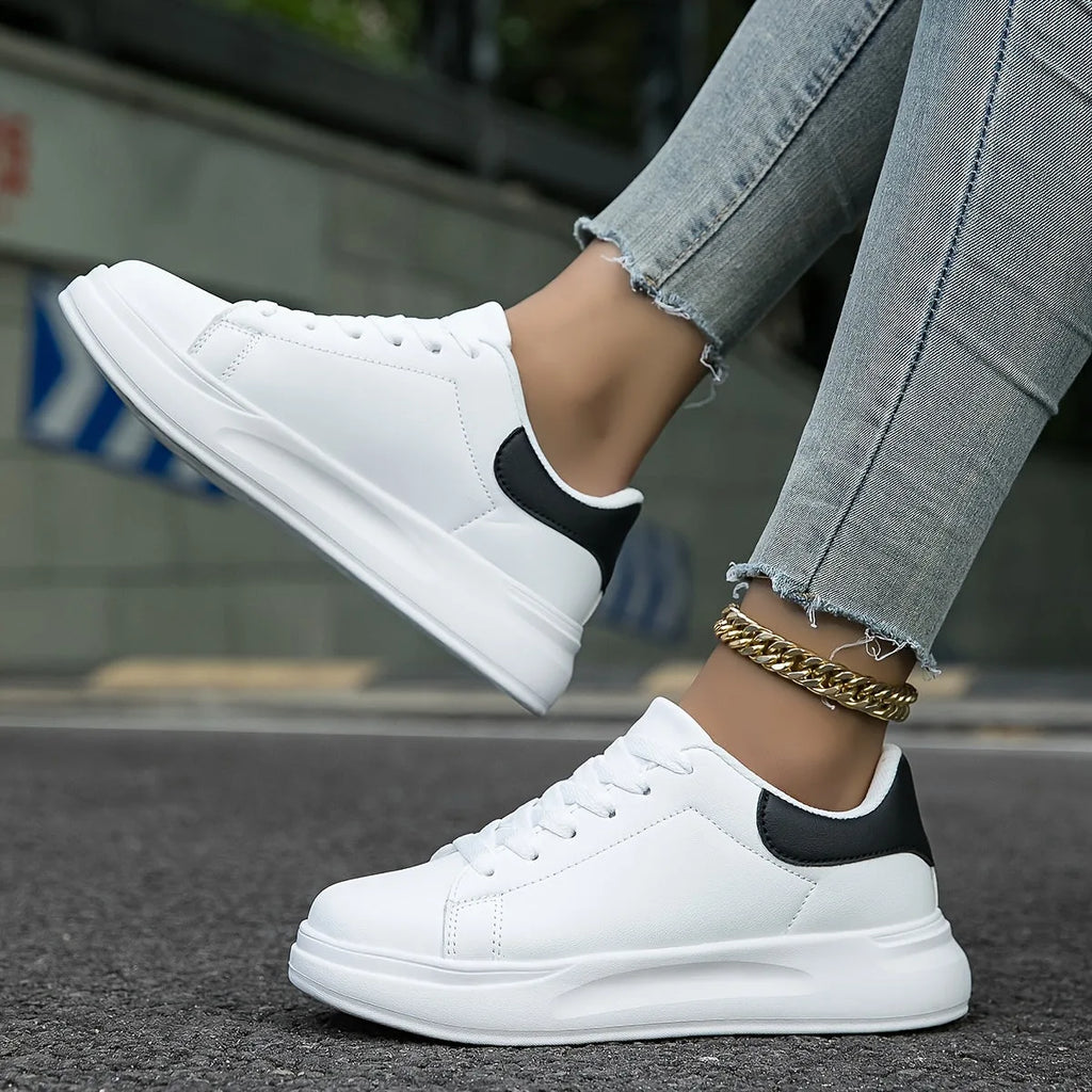 Side angle of white platform trainer with contrast black heel tab, laces loosely tied
