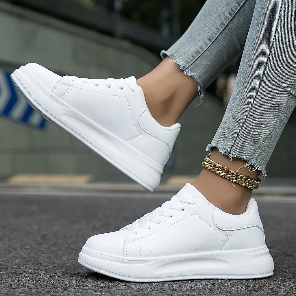 Close-up of all-white trainer front with stitched panel detail and lace-up closure