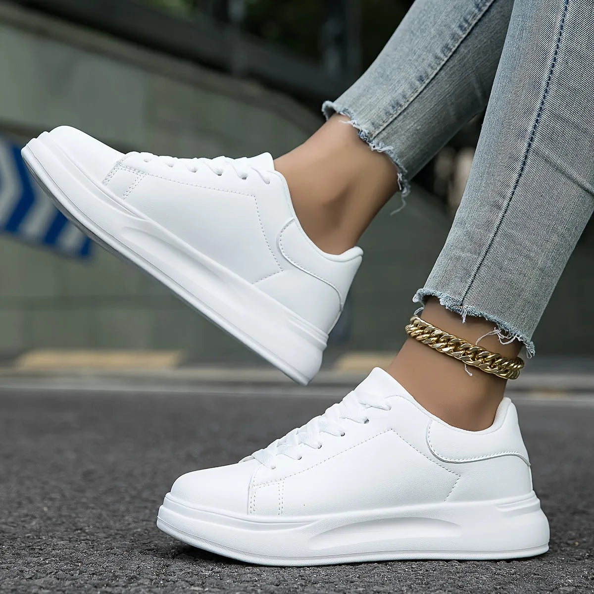Close-up of all-white trainer front with stitched panel detail and lace-up closure