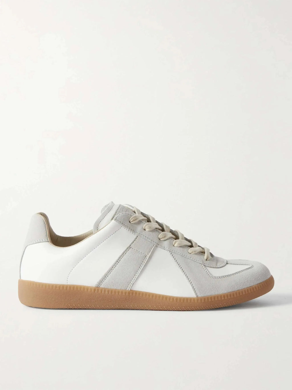 Side profile of a white leather trainer with grey suede panel stripes and a gum rubber sole