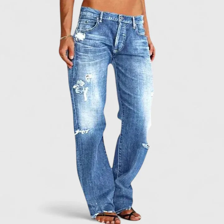 Front view of light-wash distressed jeans with wide straight legs, worn low-rise with a visible button fly.