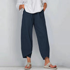 Front view of navy blue wide-leg linen-blend trousers with tulip hem, worn with a white shirt and sandals