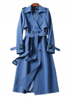 Blue double-breasted trench coat with tie belt and buckled cuffs, shown against a plain background