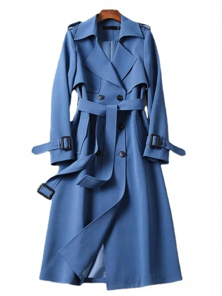 Blue double-breasted trench coat with tie belt and buckled cuffs, shown against a plain background