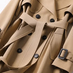 Close-up of the khaki trench coat's waist belt, button placket and buckled tab detail