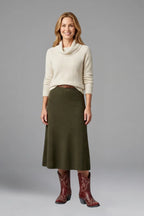 Model wearing an olive knit midi skirt and cream jumper paired with red embroidered cowboy boots